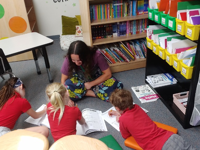 Tutor Brenna Freer works with students in French class at AXIS International Academy charter school.