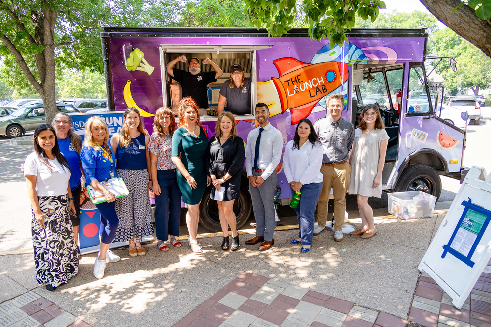 Group photo of USDA, CDE and food bank representatives in front of the Lunch Lab food truck.