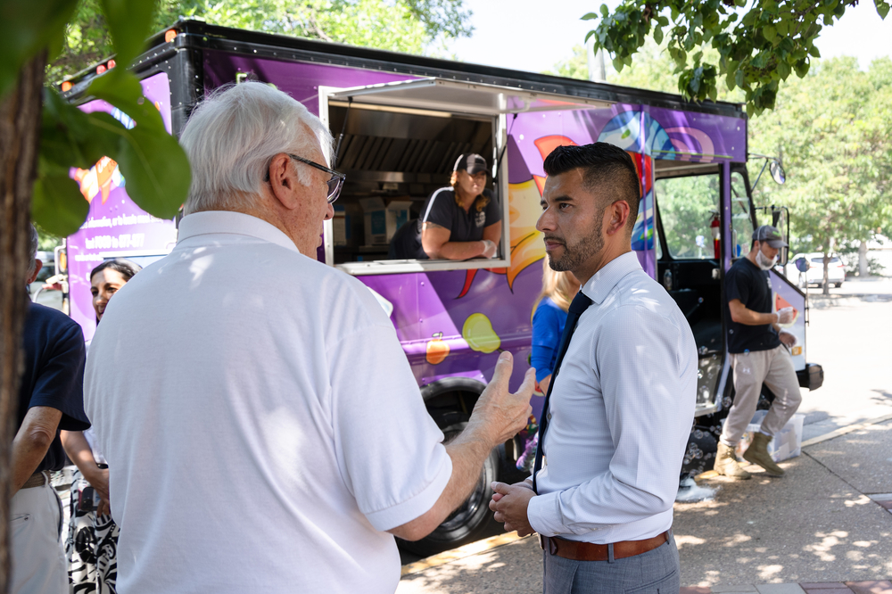 A USDA official talks with a man in front of the Lunch Lab food truck. 